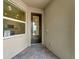 Home entryway with dark door and sidelight window at 25917 Bimini Sands Ct, Englewood, FL 34223