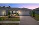 Evening view of two-unit home with attached garages at 25917 Bimini Sands Ct, Englewood, FL 34223