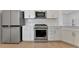 Stainless steel appliances and white cabinets in modern kitchen at 25917 Bimini Sands Ct, Englewood, FL 34223