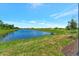 View of pond and grassy area in community at 25917 Bimini Sands Ct, Englewood, FL 34223