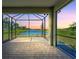 Spacious screened porch overlooking a pond at sunset at 25917 Bimini Sands Ct, Englewood, FL 34223