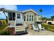 Inviting exterior of a manufactured home with landscaped yard and seating area at 289 Bainbridge Dr, Nokomis, FL 34275