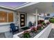 Inviting front porch with two blue chairs and lush flowers at 306 66Th St, Holmes Beach, FL 34217