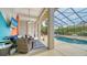 Relaxing poolside patio with wicker seating and a large TV at 3907 Bayside Dr, Bradenton, FL 34210