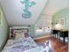 Attic bedroom featuring hardwood floors, mint green walls, a mermaid decoration, and lots of natural light at 409 Pine Ave, Anna Maria, FL 34216