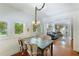 Bright dining room featuring hardwood floors, a unique light fixture, and living room access at 409 Pine Ave, Anna Maria, FL 34216