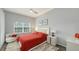 Spacious bedroom with a red comforter and a ceiling fan at 4228 Central Sarasota Pkwy # 1013, Sarasota, FL 34238