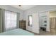 Bright bedroom with wood-look floors, mirrored closet doors, and ensuite access at 4228 Central Sarasota Pkwy # 1013, Sarasota, FL 34238