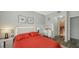 Bright bedroom with red bedding and en-suite bathroom access at 4228 Central Sarasota Pkwy # 1013, Sarasota, FL 34238