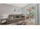 Bright living room with a comfortable sofa, access to a screened patio, and neutral decor at 4228 Central Sarasota Pkwy # 1013, Sarasota, FL 34238