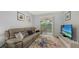 Relaxing living room features a large sectional sofa and sliding glass doors leading to a screened patio at 4228 Central Sarasota Pkwy # 1013, Sarasota, FL 34238