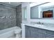 Bathroom with gray tile, a vanity with marble top, and a bathtub at 4284 Watova Ave, North Port, FL 34286