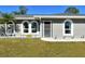 Newly renovated gray house with a lush green lawn and driveway at 4284 Watova Ave, North Port, FL 34286