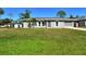 Newly renovated gray house with a lush green lawn and driveway at 4284 Watova Ave, North Port, FL 34286
