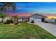 Single-story home with gray siding, landscaped lawn, and attached garage at 4430 Wynkoop Cir, Port Charlotte, FL 33948