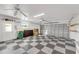 Garage with checkered floor, storage shelving, and an AC unit at 4430 Wynkoop Cir, Port Charlotte, FL 33948