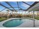 Screened pool area with kidney-shaped pool and tranquil view at 4430 Wynkoop Cir, Port Charlotte, FL 33948