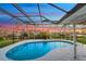 Kidney-shaped pool with a screened enclosure offering sunset views at 4430 Wynkoop Cir, Port Charlotte, FL 33948