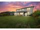 Large backyard at dusk, showcasing a covered patio perfect for outdoor relaxation and entertainment at 4886 Seafoam Trl, Bradenton, FL 34211