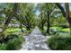 Scenic walkway with pond and lush trees lining the path at 6267 Midnight Pass Rd # 307, Sarasota, FL 34242