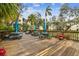 Relaxing community deck with tables, umbrellas, and surrounding landscaping at 635 30Th Ave W # F206, Bradenton, FL 34205
