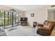 Living room with recliner, TV, and sliding glass doors to balcony at 635 30Th Ave W # F206, Bradenton, FL 34205