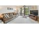 Living room with sofa, TV, and access to balcony at 635 30Th Ave W # F206, Bradenton, FL 34205