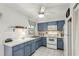 Small kitchen with white appliances and blue cabinets at 6380 S Biscayne Dr, North Port, FL 34287