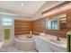 Spa-like bathroom with soaking tub and wood wall accents at 6723 Approach Rd # 35, Sarasota, FL 34238
