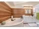 Bathroom with a soaking tub and wood-paneled accent wall at 6723 Approach Rd # 35, Sarasota, FL 34238
