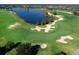 Aerial view of golf course with lake and players at 7220 Whittlebury Trl, Lakewood Ranch, FL 34202