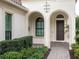 Elegant front entry with arched doorways and lush landscaping at 7220 Whittlebury Trl, Lakewood Ranch, FL 34202