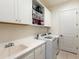 Bright laundry room with white cabinets and a sink at 7220 Whittlebury Trl, Lakewood Ranch, FL 34202