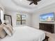 Main bedroom with king bed, large TV, and water view at 7220 Whittlebury Trl, Lakewood Ranch, FL 34202