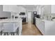 Modern kitchen featuring white cabinetry, stainless steel appliances, and a breakfast bar at 7613 Camminare Dr, Sarasota, FL 34238