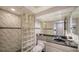 Bathroom with glass block shower and granite vanity at 800 Benjamin Franklin Dr # 202, Sarasota, FL 34236