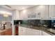 Modern kitchen with white cabinets, granite counters, and stainless steel appliances at 800 Benjamin Franklin Dr # 202, Sarasota, FL 34236