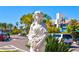 White statue of a Personal holding flowers, located near a street with cars at 800 Benjamin Franklin Dr # 202, Sarasota, FL 34236