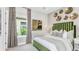 Guest bedroom with green velvet headboard, patterned curtains, and natural light at 8040 Moonbeam Avenue, Sarasota, FL 34241