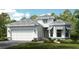 White two-story house with gray roof, landscaping, and two-car garage at 8040 Moonbeam Avenue, Sarasota, FL 34241