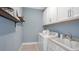 Laundry room with white cabinets and built-in shelving at 8125 Moonbeam Ave, Sarasota, FL 34241