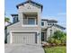 Two-story house with gray siding, balcony, and three-car garage at 8273 Shooting Star Rd, Sarasota, FL 34241