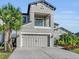 Two-story house with gray siding, balcony, and three-car garage at 8273 Shooting Star Rd, Sarasota, FL 34241