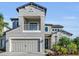 Two-story house with gray siding, balcony, and three-car garage at 8273 Shooting Star Rd, Sarasota, FL 34241