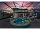 Luxury pool and spa with a covered lanai at sunset at 8273 Shooting Star Rd, Sarasota, FL 34241