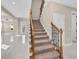Elegant staircase with wood railings and neutral carpeting at 8273 Shooting Star Rd, Sarasota, FL 34241