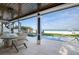 A covered patio with an outdoor dining area and views of the pool and beach at 915 N Shore Dr, Anna Maria, FL 34216