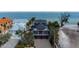 An exterior view of this house with its lush green landscape, situated right on the ocean at 915 N Shore Dr, Anna Maria, FL 34216