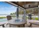 Covered patio has an outdoor dining area with grill, perfect for entertaining at 915 N Shore Dr, Anna Maria, FL 34216