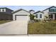 Single-story home with gray siding, two-car garage, and landscaped lawn at 9810 Eventide Trl, Parrish, FL 34219